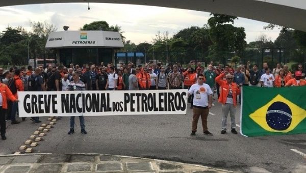Citizens hold a banner reading 'Oil workers' national strike', State of Parana, Brazil, Feb. 11, 2020.