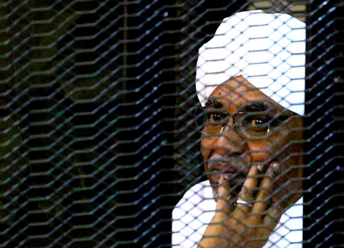 Sudan's former president Omar Hassan al-Bashir sits inside a cage at the courthouse where he is facing corruption charges, in Khartoum, Sudan September 28, 2019.