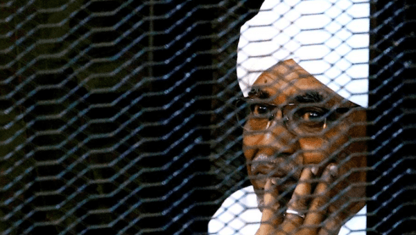 Sudan's former president Omar Hassan al-Bashir sits inside a cage at the courthouse where he is facing corruption charges, in Khartoum, Sudan September 28, 2019. 