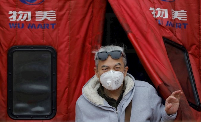 Man wearing a mask walks out of a supermarket in Beijing, China, Feb. 13, 2020.