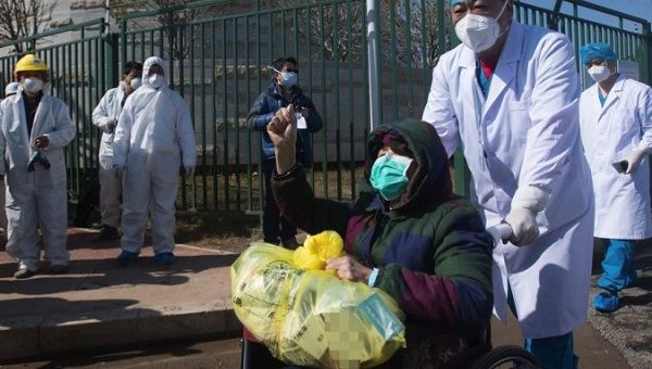 An 83-year-old woman is being discharged from a SARS treatment-model hospital in Wuhan, China, Feb. 19, 2020.