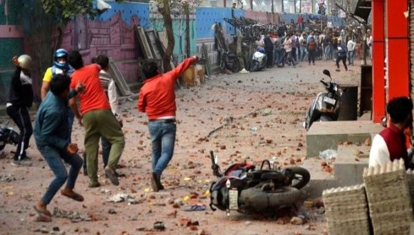 People supporting a new citizenship law and those opposing the law, throw stones at each other during a clash in Maujpur area of New Delhi, India, Feb. 23, 2020. 