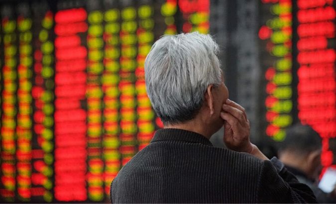 An investor looks at an electronic board showing stock information at a brokerage house in Nanjing.