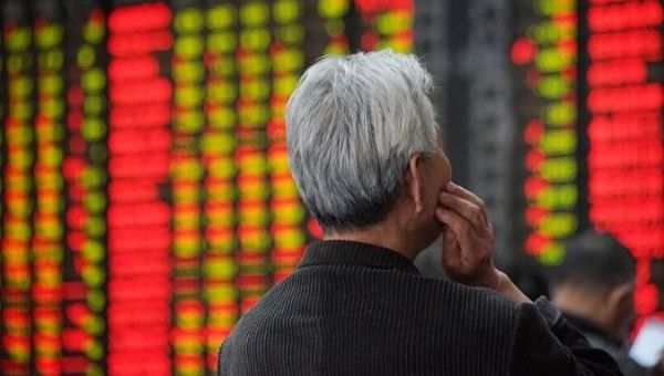 An investor looks at an electronic board showing stock information at a brokerage house in Nanjing.