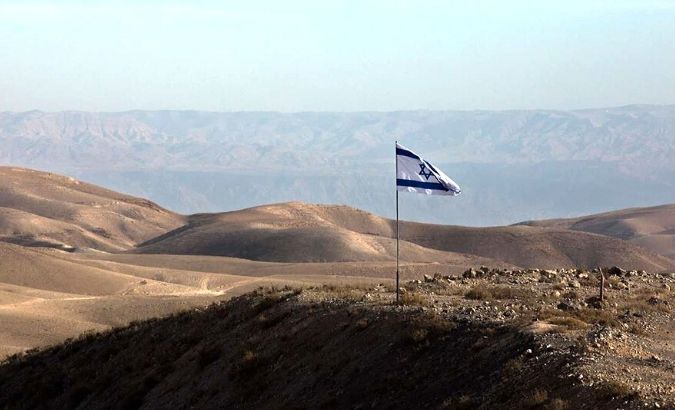 An Israeli flag flies over an area in the occupied West Bank.