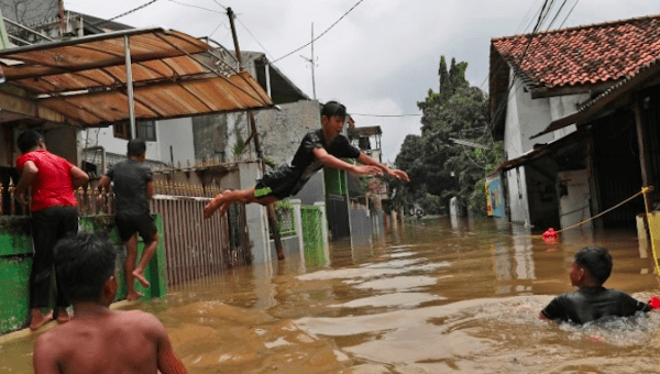 Indonesian youths play in flood waters in a neighborhood in Jakarta on Feb. 25. 