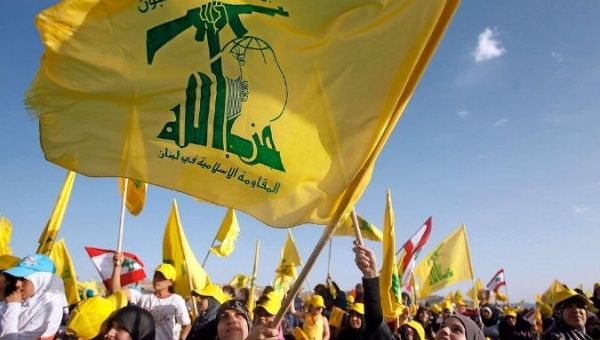 Supporters of Hezbollah wave their organization's flag.