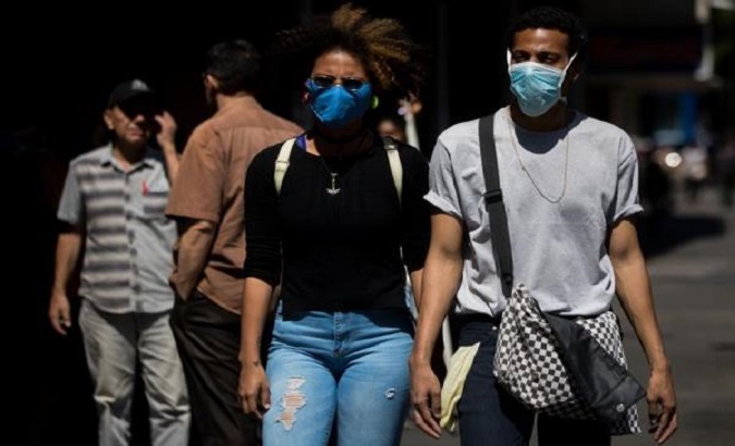Citizens walk with nasobucos in the streets of Caracas, Venezuela, March 14, 2020.