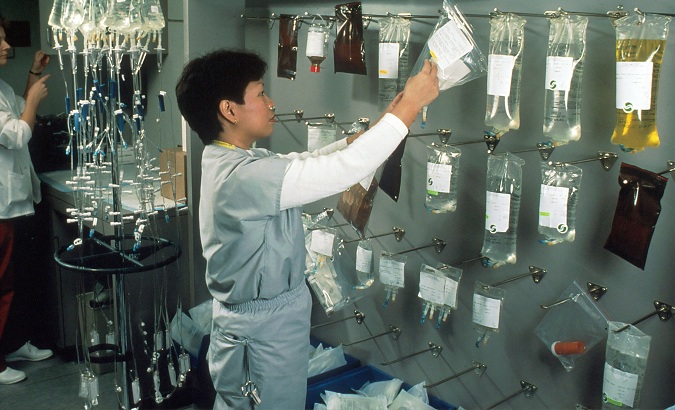 Woman arranging Intravenous therapy (IV) bags.