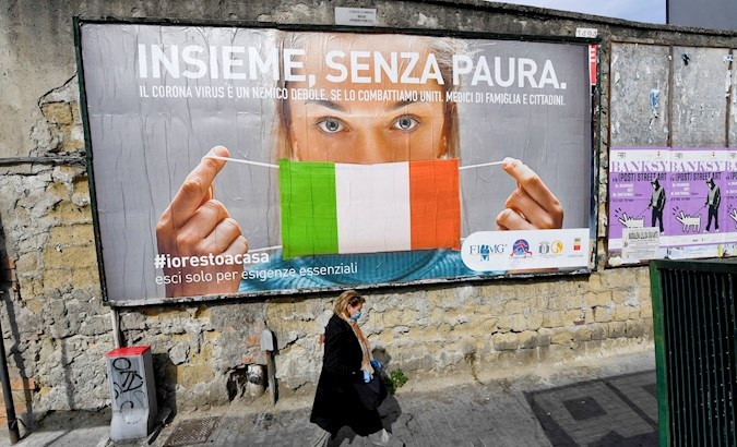 A woman passes a large billboard that reads 'Together, without fear', Naples, Italy, March 21, 2020.