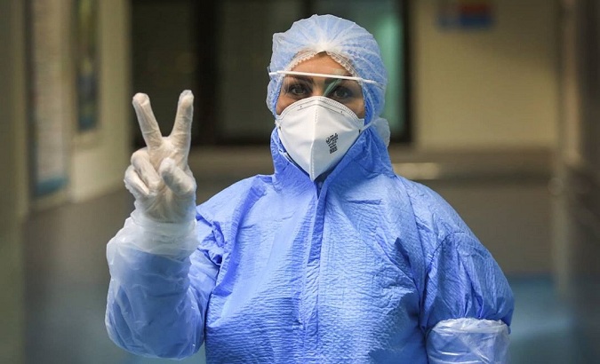 Iranian doctor makes a gesture of peace while caring for his patients, Teheran, Iran, March 24, 2020.