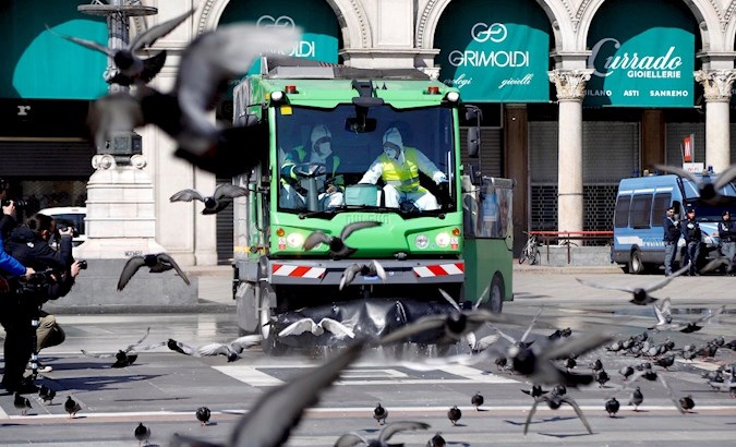Sanitation workers carry out the cleaning of Duomo Square, Milan, Italy, March 31, 2020.