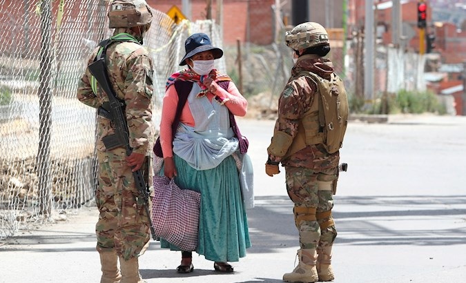 Military ask an Indigenous woman who is going to buy food for her identity document, Bolivia, March 31, 2020.