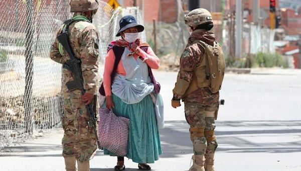 Military ask an Indigenous woman who is going to buy food for her identity document, Bolivia, March 31, 2020.