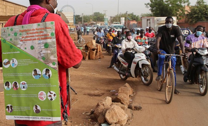 A man wears an information poster to deliver information on Covid-19, Ouagadougou, Burkina Faso, March 30, 2020.