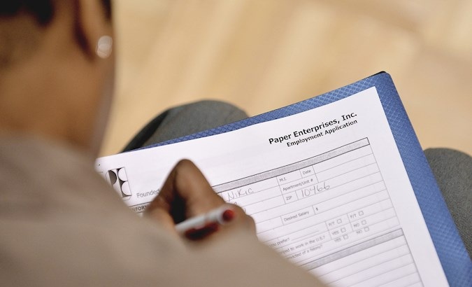 Man filling out an employment application at a community center, New York, U.S., April 3, 2020.