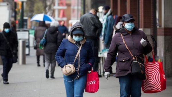 Pedestrians wearing face masks are seen in a street in the Brooklyn borough of New York, the United States, on April 3, 2020.