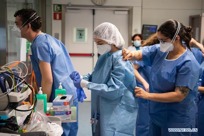 Medical workers put on protective suits at a hospital in Barcelona, Spain, March 20, 2020.