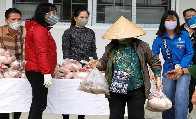 Vietnamese volunteers citizens delivering food to the needy