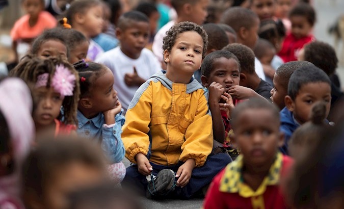 Children wait to receive food in Ocean View, Cape Town, South Africa, April 13, 2020.