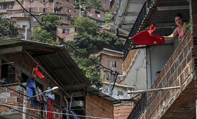 People with red clothes ask for help in Commune 13 in Medellin, Colombia. April, 2020.