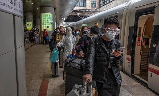 Passengers from Wuhan wait in line at a train station, Beijing, China, April 15, 2020.