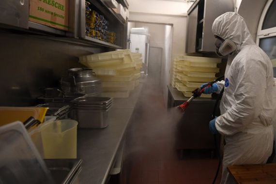A staff member sprays disinfectant in a restaurant in Rome, Italy, April 22, 2020.
