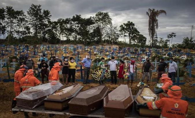 People attending a funeral at a collective grave, Manaus, Brazil, April 23, 2020.
