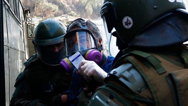 Military police detain Juan Jordan as he shows his journalist credential, Valparaiso, Chile, May 1, 2020.
