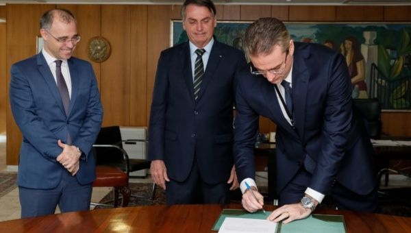 Brazilian President Jair Bolsonaro signs a document.