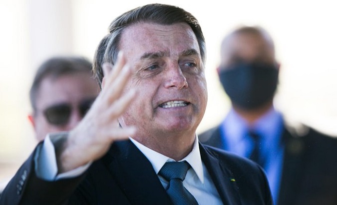President Jair Bolsonaro gestures against journalists as he leaves his headquarters, Brasilia, Brazil, May 5, 2020.