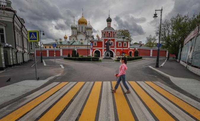 A woman walks in front of Zachatievsky Stavropegial Convent, Moscow, Russia, May 7, 2020.