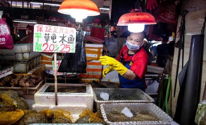 A vendor wearing a mask sells live turtles on Xihua Farmer's Market in Guangzhou, Guangdong province, China, May 4, 2020.