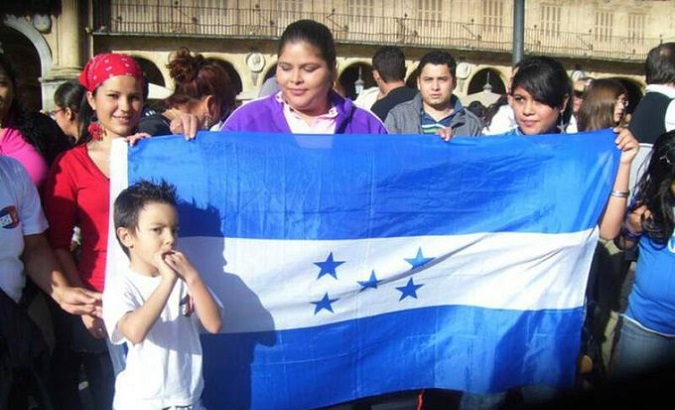 Homeless Hondurans hold their country's flag, Madrid, Spain, May 11, 2020.