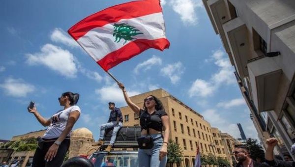 Protesters wave flags in front the Parliament, Beirut, Lebanon, May 7, 2020.
