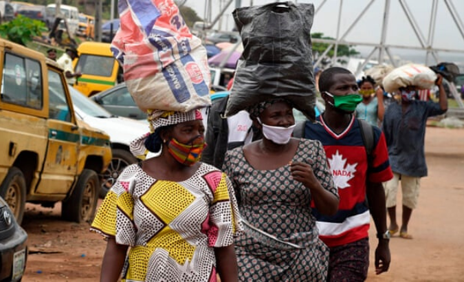 People wear face masks in compliance with state rules in Ojodu-Berger, Lagos, Nigeria.