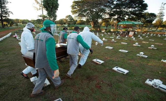 Workers at Campo de Esperanza cemetery bury COVID-19 victim, Brasilia, Brazil, May 21, 2020
