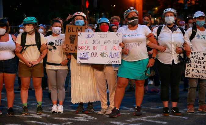 Mothers create a human wall to protect protesters from the police brutality, Portland, U.S., July 19, 2020.