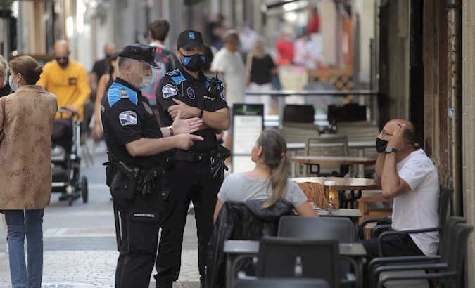 Police speak with a man who smoked on a terrace of a bar, Coruña, Spain, August 13, 2020.