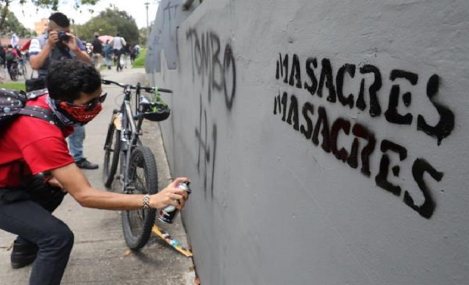 A student draws a graffiti during a protest against massacres in Bogota, Colombia, August 28, 2020.