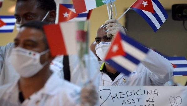 Cuban doctors wave Cuban and Italian flags upon their arrival from Europe to Havana, Cuba. June 8, 2020. 
