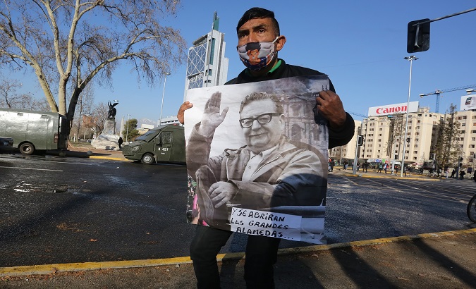 A man holds an image of former Chilean President Salvador Allende during a protest to commemorate the 47th anniversary of the coup d'état and the beginning of the dictatorship today, at Plaza Italia in Santiago de Chile, Chile. September 11, 2020.