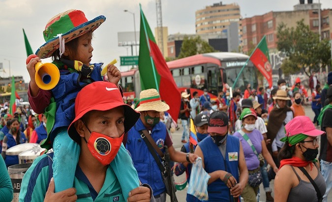 A father and daughter march alongside the Social Minga, Bogota, Colombia, Oct. 19, 2020.