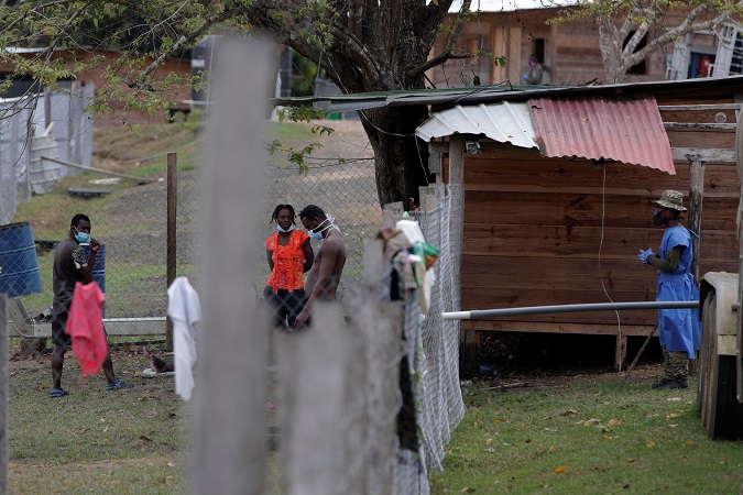 Migrants talk to an agent of the National Border Service of Panama (Senafront), in the community of Lajas Blancas, in Darien (Panama), in April.