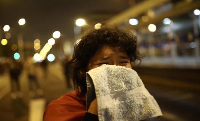 A person is affected by tear gas fired by the police during a protest in Lima, Peru, November 12, 2020.