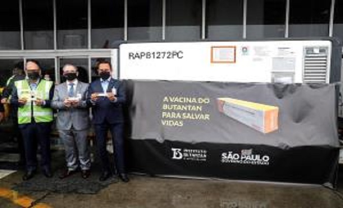 The Governor of Sao Paulo Joao Doria (R) accompanied by the Director of the Butantan Institute Dimas Covas (L) and the Secretary of Health of the State of Sao Paulo Jean Gorinchteyn (C), pose next to the first lot of the 