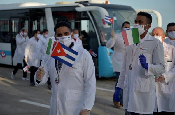 Cuban doctors from the Henry Reeve Medical Brigade wave Cuban and Italian flags after their arrival from Italy to Havana, Cuba. June 08, 2020.