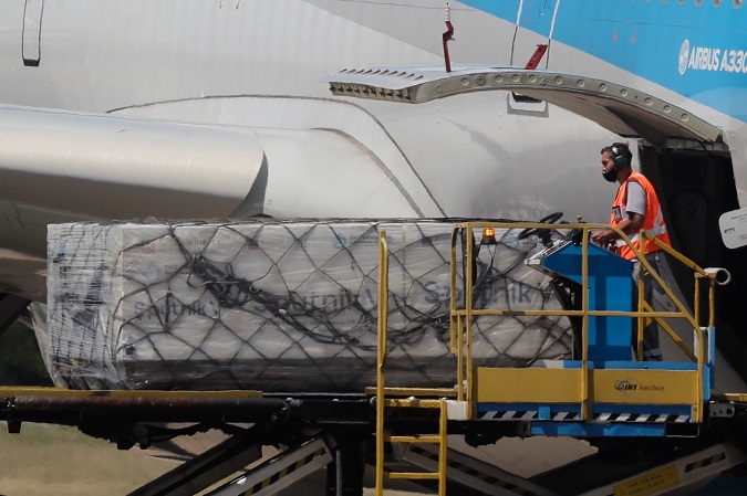 Operators unload an Aerolineas Argentinas plane the first containers of the Russian Sputnik V vaccine against COVID-19 on December 28.