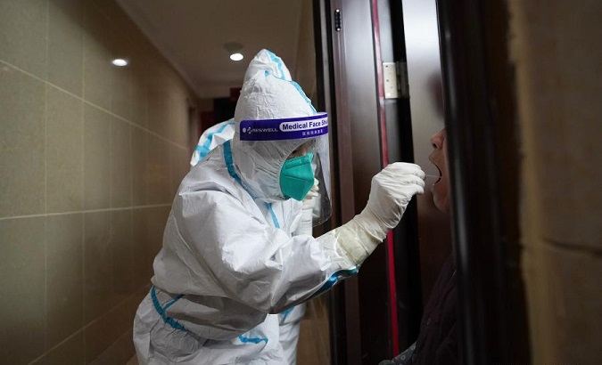Medical workers carry out door-to-door nucleic acid sampling on the elderly who have difficulty in moving in Beijing, China, Dec. 28, 2020.