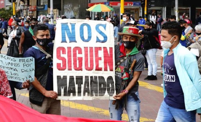 Citizens hold a sign that reads, 'We are still getting killed' during a protest, Bogota, Colombia, Nov. 5, 2020.